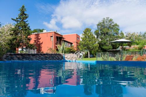 a swimming pool in front of a house at Nuevas Cabañas Del Sol in San Lorenzo