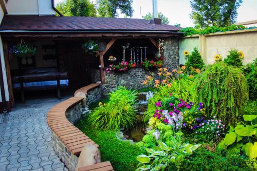 a garden with flowers and a stone pathway at Nashe Misto Guest House in Kovelʼ