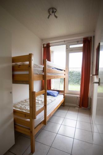 a bedroom with two bunk beds and a window at Appartement Walvis nr. 16 in Vrouwenpolder
