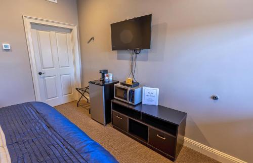 a bedroom with a bed and a tv on the wall at Inn at Elijah McLean's in Washington