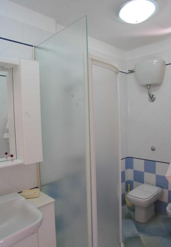 a bathroom with a toilet and a glass shower at Residence Fontana Barone in Cefalù