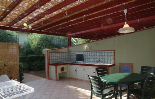 eine Terrasse mit einer Küche sowie einem Tisch und Stühlen in der Unterkunft Residence Fontana Barone in Cefalú