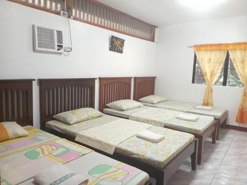 a group of four beds in a room at Felipa Beach Residence - Ilang Ilang in Dumaguete
