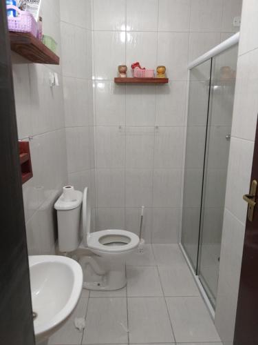 a bathroom with a toilet and a shower and a sink at Casa Martim de Sá in Caraguatatuba