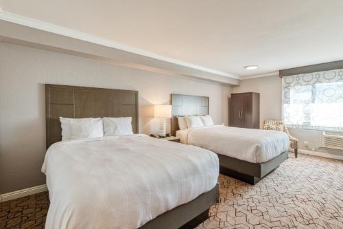 a hotel room with two beds and a window at Amanzi Hotel, an Ascend Collection Hotel in Ventura