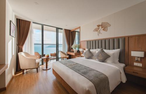 ein Hotelzimmer mit einem großen Bett und einem Schreibtisch in der Unterkunft Grand Gosia Hotel in Nha Trang