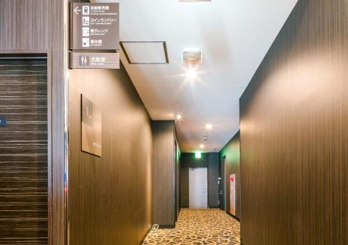 a hallway in a hospital with a sign on the ceiling at APA Hotel Nagasaki-eki Minami in Nagasaki