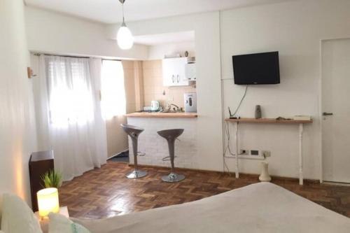 a living room with a television and a kitchen at Mar de Anto in Puerto Madryn