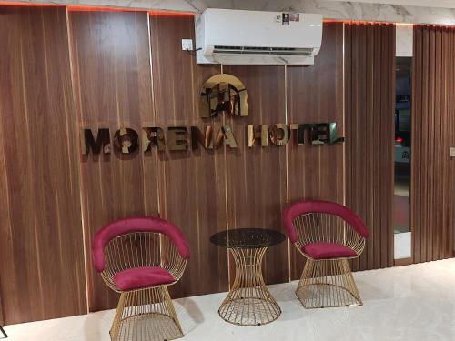 two chairs and a table in front of a welcome sign at Hotel Morena Batam in Batam Center