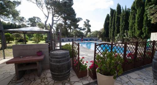 um pátio com uma mesa e uma cerca com uma piscina em Maison de Maitre for 10 people in the heart of the vineyard em Badens