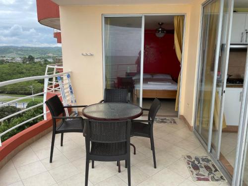 a balcony with a table and chairs and a bedroom at Apartamento en Atacames con vista al mar in Atacames