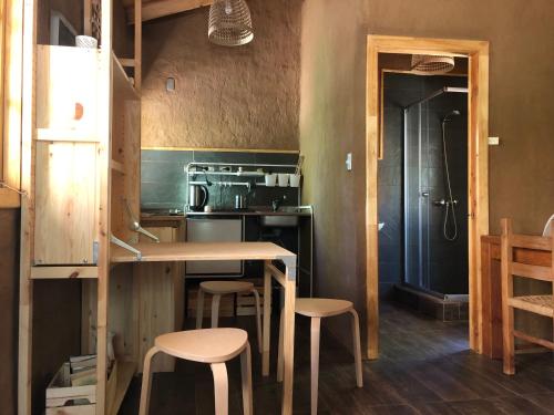 a kitchen with a table and stools in a room at Puma Cottage in Horcon