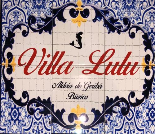 a sign that is on a blue and white wall at Villa Lulu Geribá in Búzios