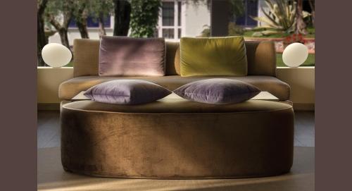 a brown couch with four pillows on top at Hotel Désirée - Garda Lake Collection in Sirmione