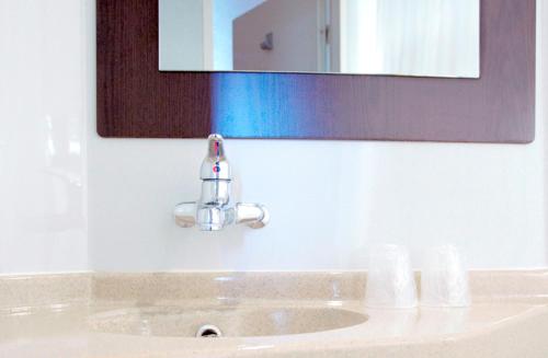 a bathroom sink with a faucet and a mirror at Premiere Classe Lille Ouest - Lomme in Lomme