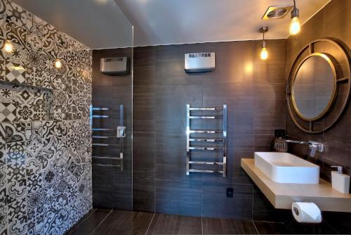 uma casa de banho com um lavatório e um espelho em Arrowtown Red Cottage with Spa em Arrowtown