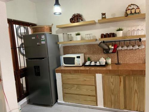 a kitchen with a refrigerator and a microwave at Villa Maria Paula in Jarabacoa