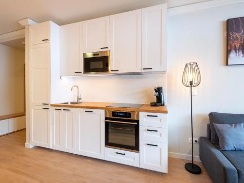 a kitchen with white cabinets and a microwave at Holiday apartment in Zwieselstein near S lden in Sölden