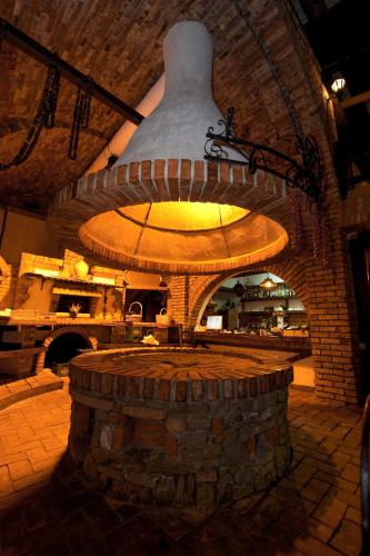 a large brick oven with a large bell in a building at Hotel Restaurant Bujtina e Gjelit in Tirana
