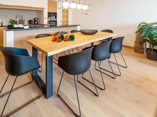 uma cozinha com uma mesa de madeira e cadeiras em Luxurious Crystal Sea View apartment with 2 terraces em Oostende