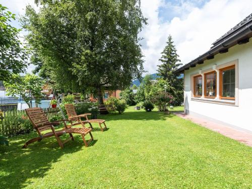 a yard with two benches and a tree at Holiday home in Bad Mitterndorf near ski area in Bad Mitterndorf