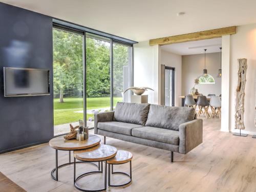 a living room with a couch and a table at Tranquil Farmhouse in Rijsbergen with Hot Tub and Garden in Rijsbergen