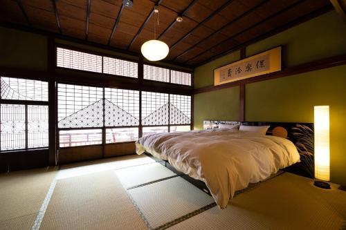 a bedroom with a bed in a room with windows at Ryusuke25 - Vacation STAY 71742v in Komatsu