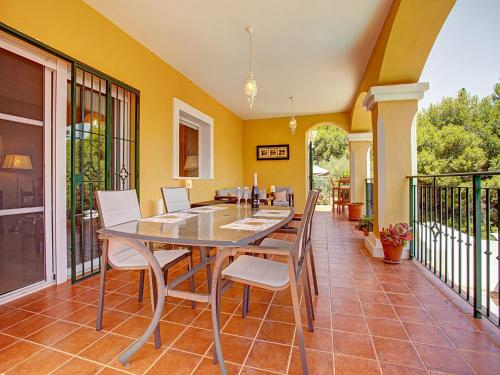 comedor con mesa y sillas en el balcón en Belvilla by OYO Casa Amarilla Blanca, en Salobreña
