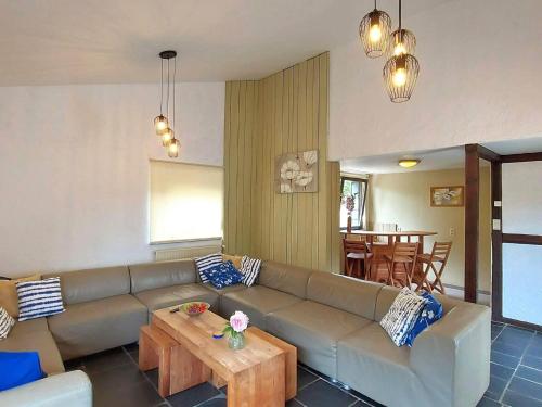 ein Wohnzimmer mit einem Sofa und einem Tisch in der Unterkunft Holiday home near Malmedy with sauna bubble bath in Malmedy