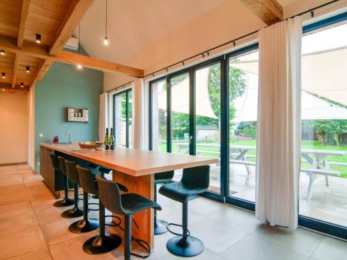 a kitchen with a wooden table and chairs and large windows at Holiday Home in Bocholt with Fenced Garden in Bocholt