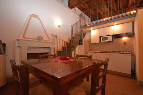 una sala da pranzo con tavolo in legno e scala di Antica Residenza del Gallo a Lucca