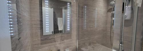 a bathroom with a shower with a mirror at Garland Stylish Apartment 1 in Greater London in London