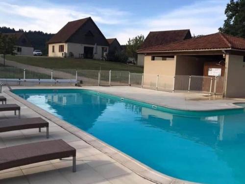 een groot blauw zwembad met een huis op de achtergrond bij Holiday home at Lacapelle Marival in Lacapelle-Marival