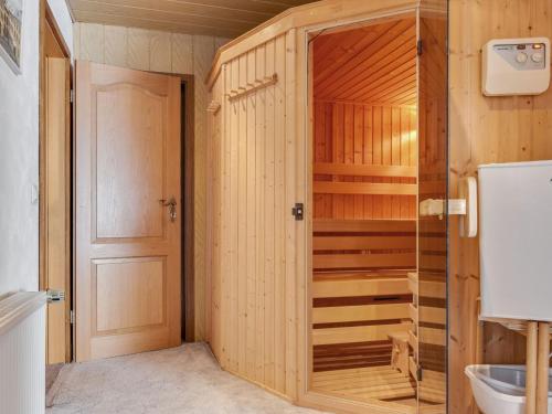 a bathroom with a closet with a toilet and a door at Beautiful Apartment in Blankenburg Harz with Sauna in Wienrode
