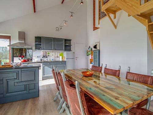 - une cuisine avec une table et des chaises en bois dans l'établissement Beautiful and spacious holiday home with p tanque court and countryside views, à Somme-Leuze