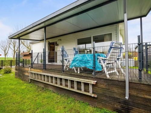 eine Veranda mit zwei Stühlen und einem Tisch darauf in der Unterkunft Alluring Chalet in Lith with Terrace and Garden in Lith