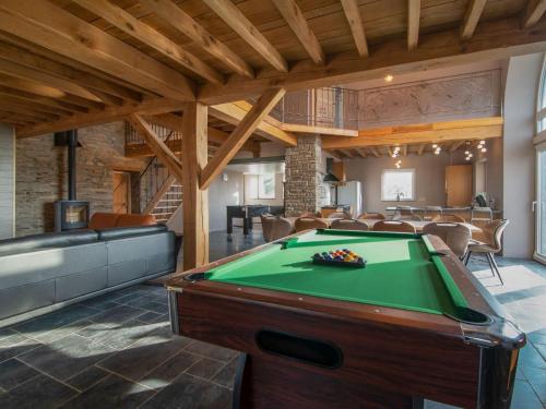 um quarto grande com uma mesa de bilhar numa casa em Very spacious house with sauna spa and countryside views em Gouvy