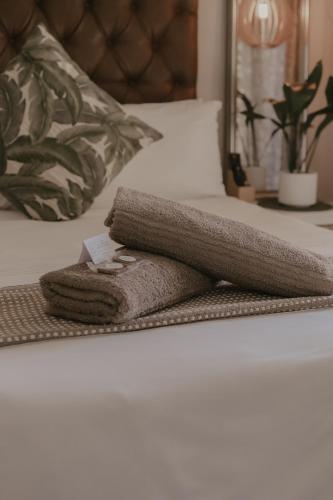a pile of towels sitting on a bed at Villa Rose Guesthouse & Venue in Bloemfontein