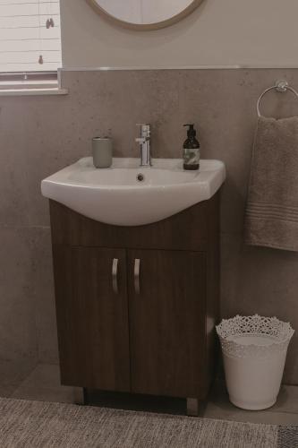 a bathroom with a sink and a mirror at Villa Rose Guesthouse & Venue in Bloemfontein