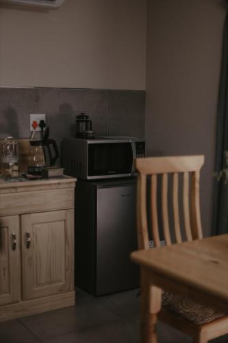 a kitchen with a microwave oven and a stove at Villa Rose Guesthouse & Venue in Bloemfontein