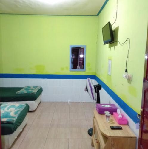 Телевизор и/или развлекательный центр в Hotel Indah Grogot Syariah Mitra RedDoorz