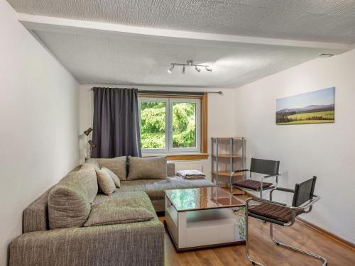 a living room with a couch and a table at Apartment with private terrace in Benneckenstein