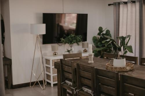 a dining room with a table and chairs and a lamp at Villa Rose Guesthouse & Venue in Bloemfontein
