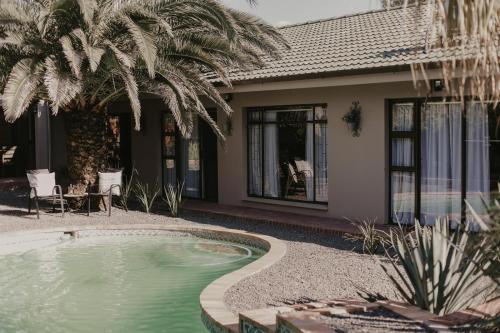 a house with a swimming pool in front of a house at Villa Rose Guesthouse & Venue in Bloemfontein