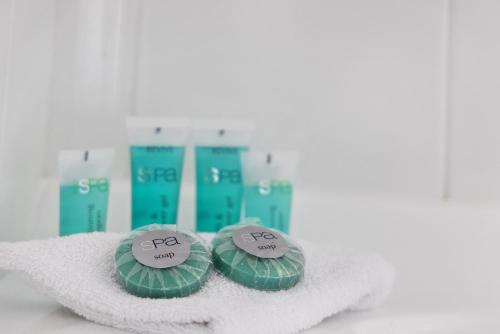 two green spa products sitting on a pile of towels at Seaside Holiday Resort in Fingal Bay