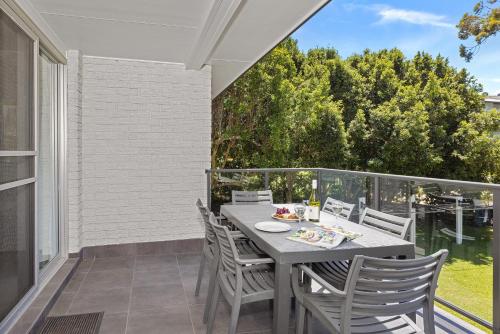 a patio with a table and chairs on a balcony at Seaside Holiday Resort in Fingal Bay