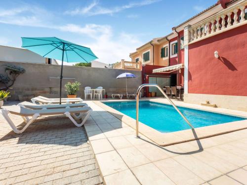 uma piscina com uma cadeira e um guarda-sol ao lado de um edifício em Belvilla by OYO Villa Malen s Mallorca em Llucmajor