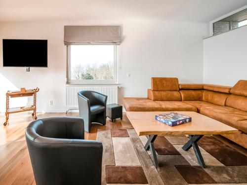 uma sala de estar com um sofá e uma mesa em Beautiful holiday home in Huy with a terrace em Huy