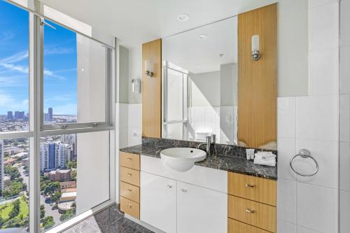 a bathroom with a sink and a large window at Towers of Chevron - Private Apartments - Hosted by Coastal Letting Co. in Gold Coast