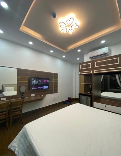a bedroom with a bed and a tv on the wall at Winston Hotel Riverside in Ho Chi Minh City